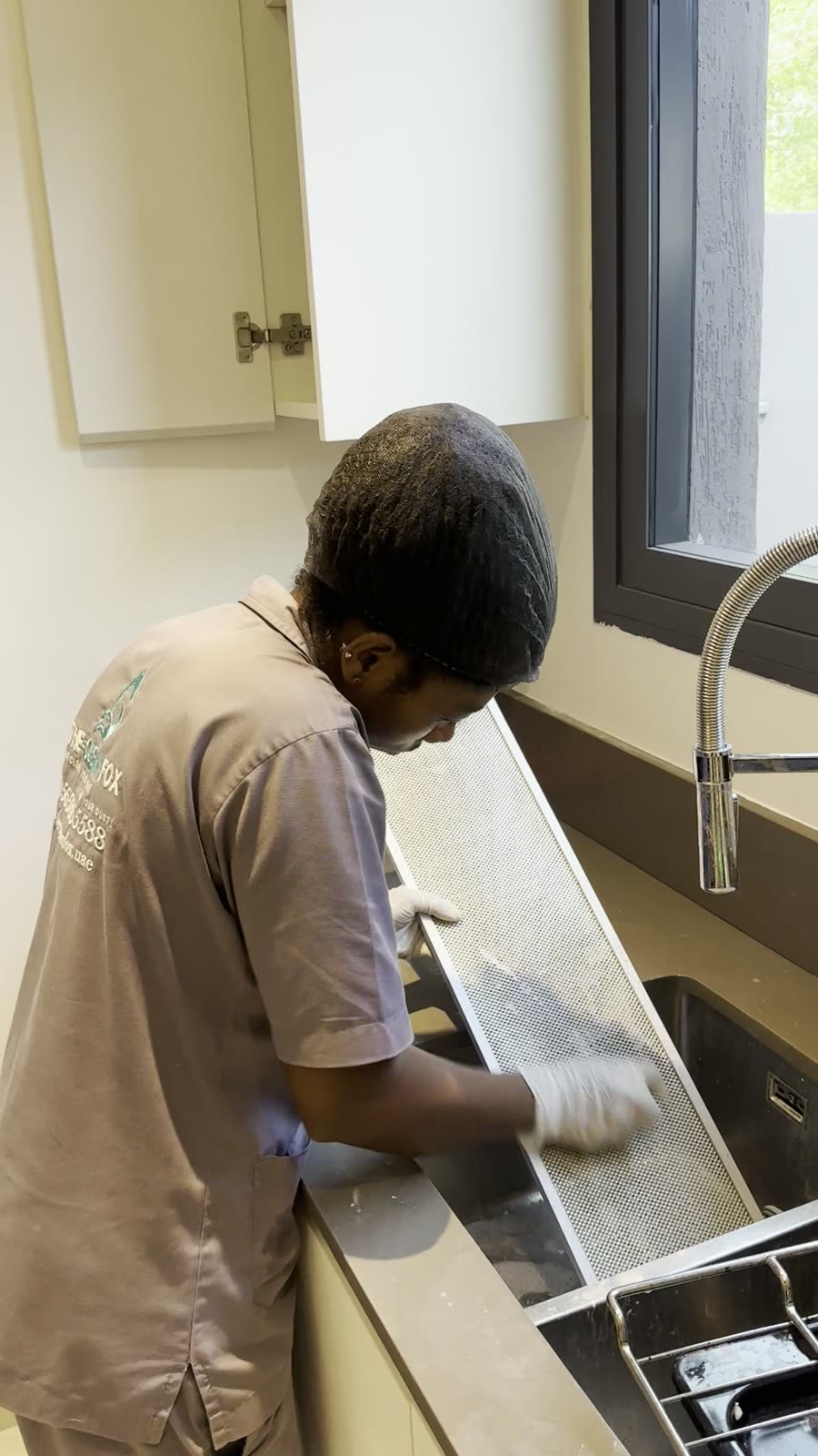 Arbeitsplatte und Spuele werden mit Handschuhen gereinigt